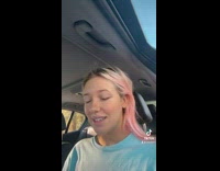 Girl sitting in car with owl in hand 