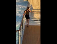 Woman black dress poses for ship photo