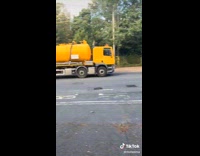 Woman stands in line with cars for gas 