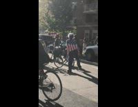 Lady american flag shirt dances street bicycle