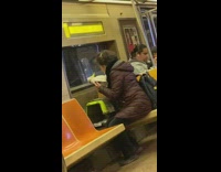 Woman pets white bird on cage inside subway train