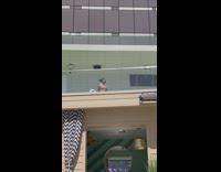 Shirtless Man Films Video in Circle on Balcony