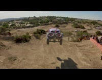 Purple car drives over a truck 