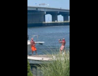 Man red skin flexes muscle at docks