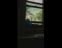 Catwoman whips The Joker on house rooftop with a whip outside window