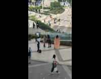 Four women turn head sit slowly plaza