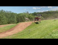 Guy on motocross bike goes up a hill and does a trick in slowmo 