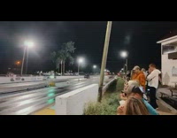 Blue truck wheelie races white truck racetrack  