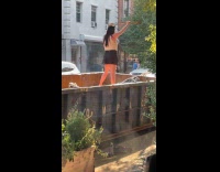 Woman stand in dumpster hold stick up