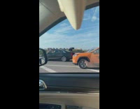 Two Vehicles Drive Slowly on a Skyway Exit