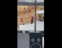 Mother and daughter lean on boat railing