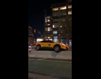 Taxi cab drives over concrete road barrier