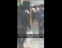 Guy wears pants tag still on mall