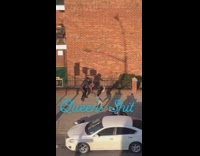 Two women fake fight on sidewalk