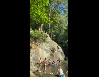 Guy jumps rock belly flops lake water