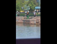 Two girls mouse ears pose beside water