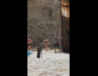 man pose old rusted ship on shore
