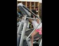 Young girl on elliptical with giant bag of chips