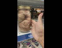 Jar of people preserves with funny eyes in store 