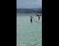 Girl try to balance on paddle board beach