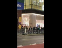 Guys dance on sidewalk by large menorah 