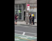 Three people wearing dog masks on sidewalk