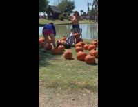 Woman lied down on the ground with pumpkins around her
