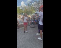 Woman in white tank top red shorts dances on the park
