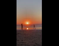 Girl frolic raise arms beach sunset silhouette