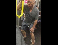Old man moves his body sensually while holding onto yellow handrail on subway station