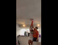Couple holds up kid with scooter on ceiling