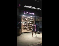 Man in only boxers plays the flute while dancing in front of liquor store