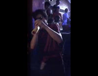 Music guy with dark glasses on in club plays with yellow toy 