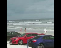 Girl bikini kneel beach parked cars overcast