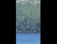 Woman in black top poses with splash effect at the beach
