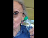 Lady in car holds noisy empty bottle 