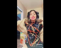 Girl lifts silver dumbbell in fur coat 