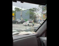Crossing guard standing at corner of intersection dancing 
