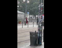Woman in red dress tosses and drops bag