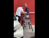 Two people with grill sidewalk parking lot