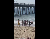 Girls hold hands unsynchronized jump shot beach
