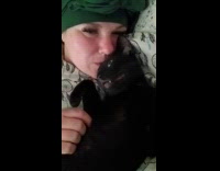 Woman lie down kisses cat beside her