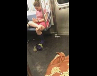A woman in pink with her bare foot out on subway train