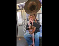Man plays the Sousaphone inside the train