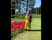 Man holds woman leaning from the flower field