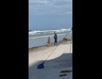 Woman kneel beach two USA flag beside butt