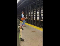 Guy holding a guitar dancing on subway platform and singing acapella 

