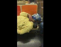 Guy in luchadore mask laying down on subway seat on portable speakers
