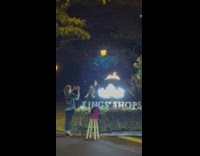 Woman pose beside Kings Shops sign fire