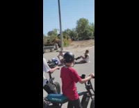 Couple attempts jump up  roadside ditch and fall of dirt bike